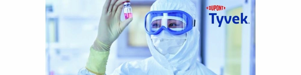 person in PPE holding a vial
